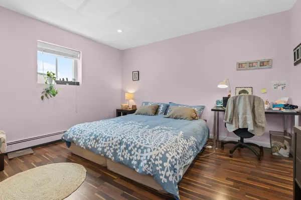 a bedroom with bed and wooden floor
