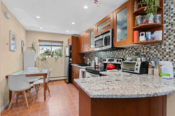 a kitchen with stainless steel appliances granite countertop a sink and a refrigerator