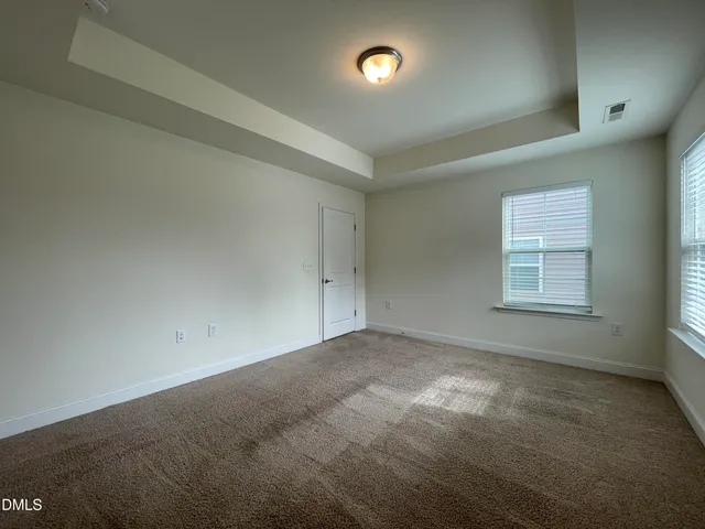 a bedroom with a large bed and a flat tv screen on dresser
