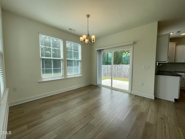 a kitchen with a refrigerator a stove top oven and wooden floor