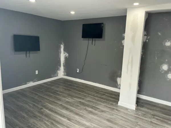 a view of a livingroom with wooden floor and a flat screen tv