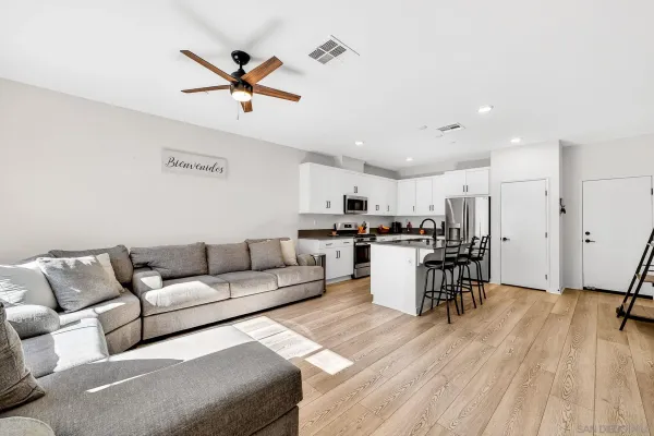 a kitchen with granite countertop lots of white cabinets stainless steel appliances and dining table