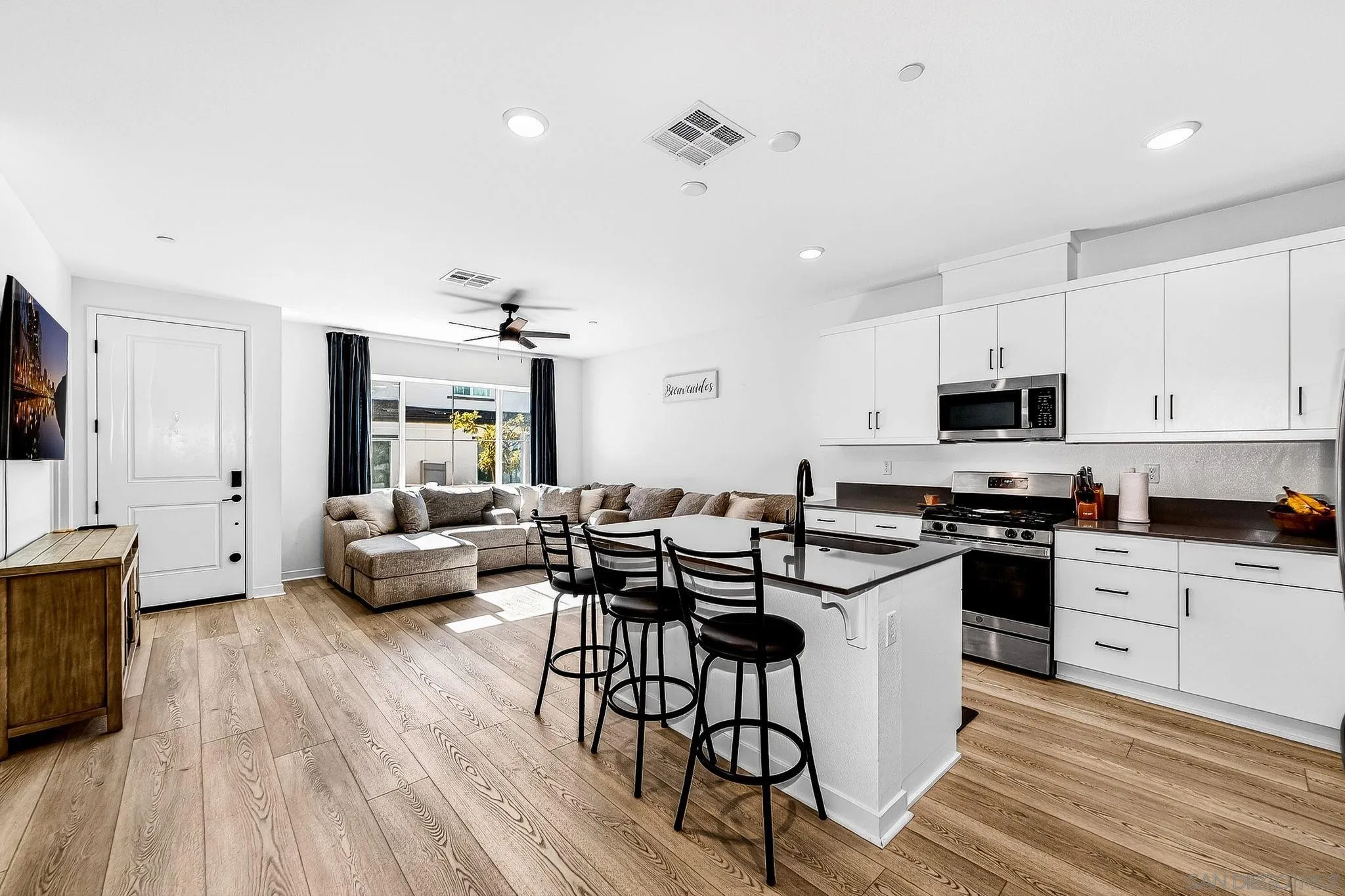 307 Seedling Way Fallbrook, CA 92028 - Photo 5 of 20 a kitchen with granite countertop lots of white cabinets stainless steel appliances and dining table