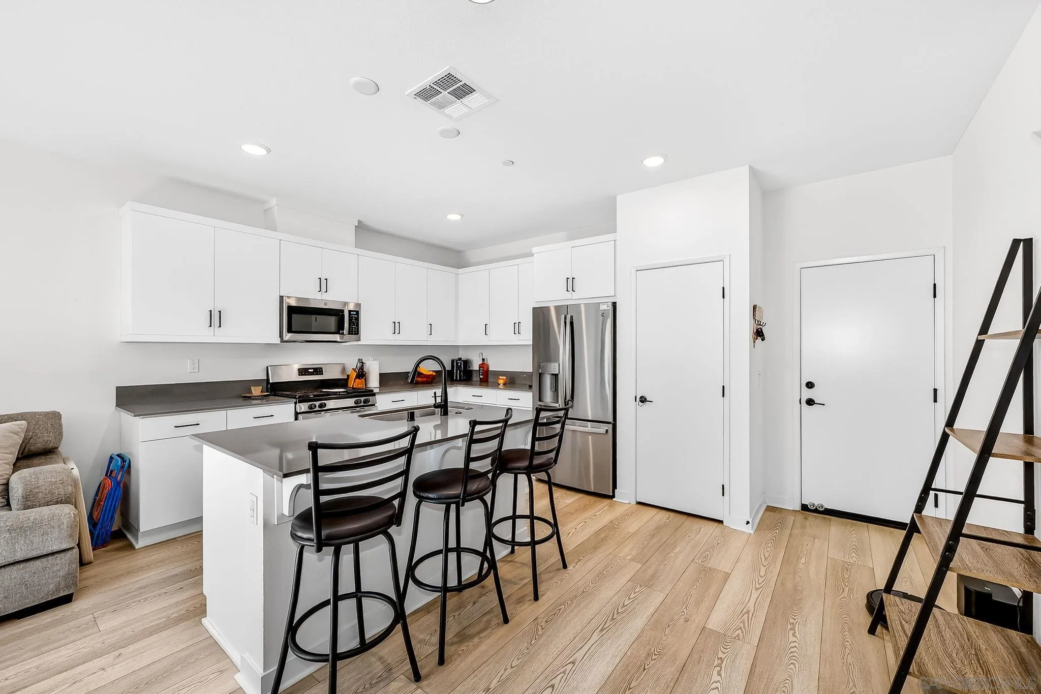 307 Seedling Way Fallbrook, CA 92028 - Photo 7 of 20 a kitchen with stainless steel appliances a refrigerator a stove a sink dishwasher and a stove with wooden floor
