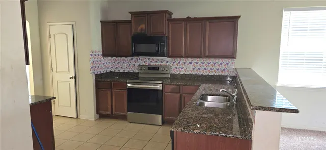 a kitchen with granite countertop a stove and a refrigerator