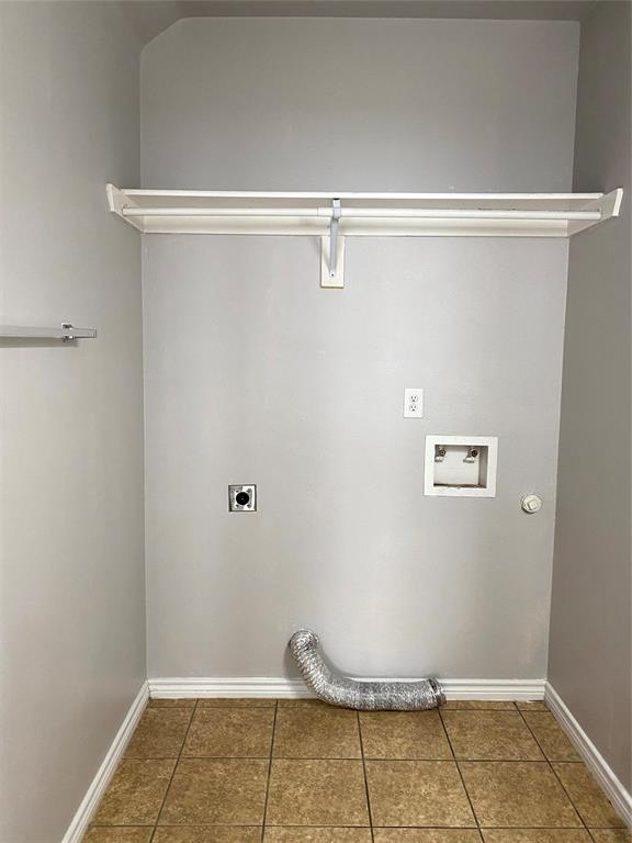 906 Parkplace Ridge Princeton, TX 75407 - Photo 11 of 31 Dedicated laundry space featuring neutral-toned walls, a white storage shelf, durable tiled flooring, and essential hookups for appliances
