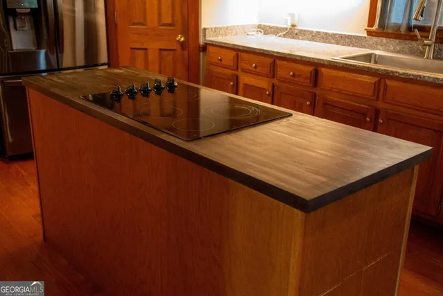 a kitchen with stainless steel appliances granite countertop a sink a stove counter space and cabinets