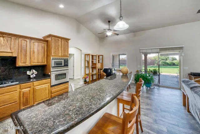 a kitchen with stainless steel appliances granite countertop a refrigerator and a stove top oven