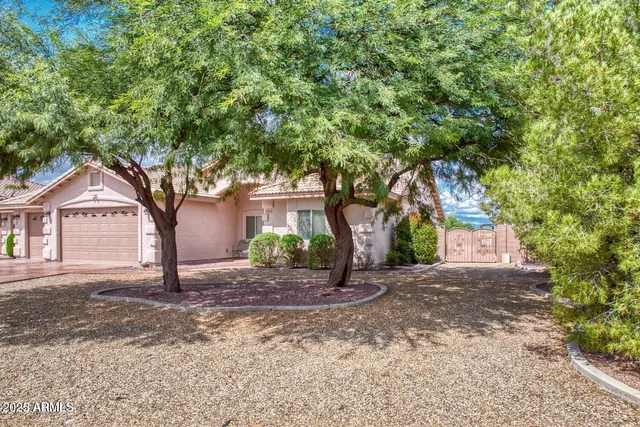 a front view of a house with a yard and an trees