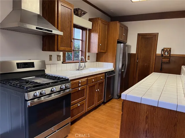 a kitchen with stainless steel appliances granite countertop a stove a sink and a refrigerator