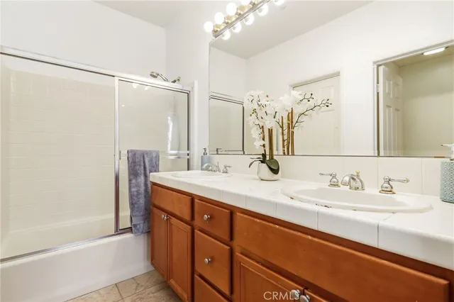 a bathroom with a double vanity sink mirror and shower