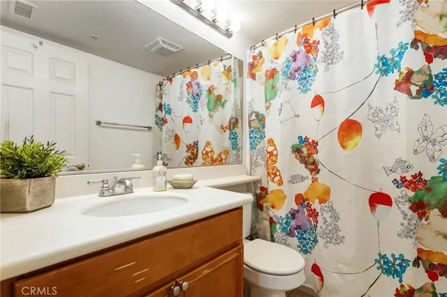 a bathroom with a sink a toilet and a curtain