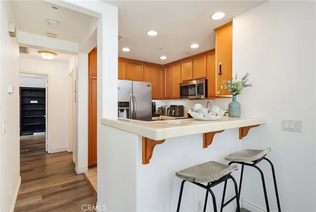 a kitchen with stainless steel appliances granite countertop a refrigerator a stove a sink and a microwave