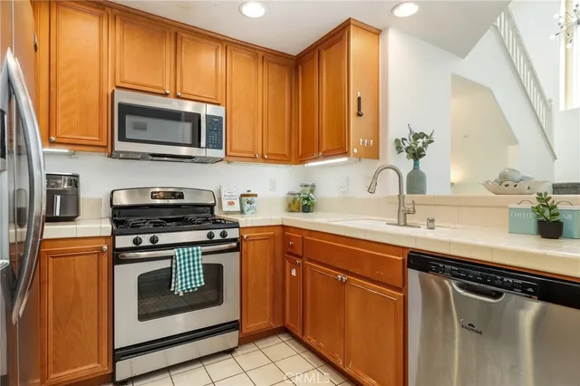 a kitchen with stainless steel appliances granite countertop a sink stove and microwave