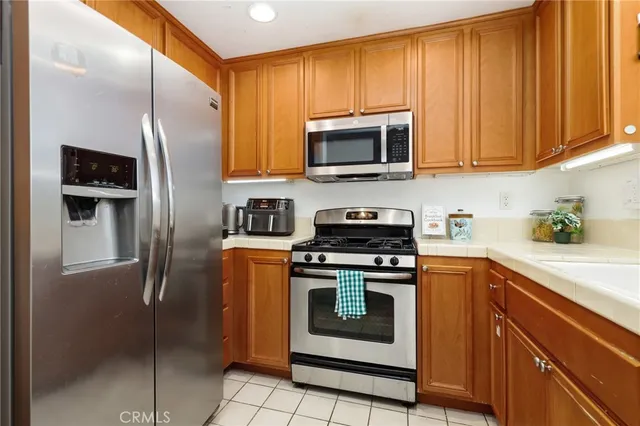 a kitchen with stainless steel appliances granite countertop a refrigerator stove and microwave