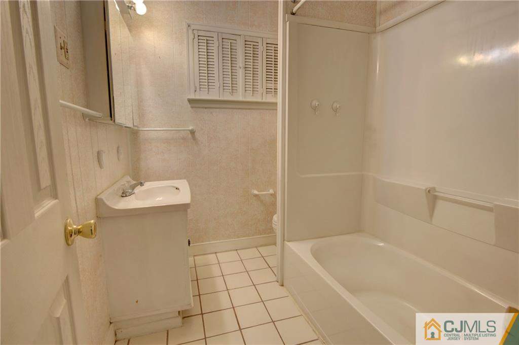 38 Tunison Road New Brunswick, NJ 08901 - Photo 16 of 18 a bathroom with a sink a toilet and shower