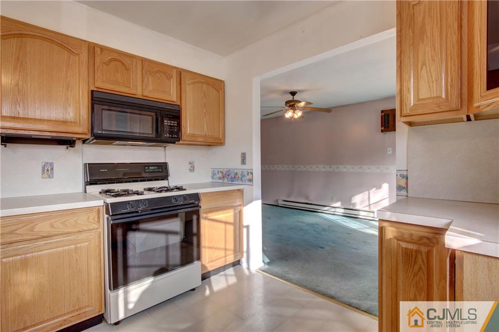 38 Tunison Road New Brunswick, NJ 08901 - Photo 5 of 18 a kitchen with granite countertop a stove top oven microwave and cabinets