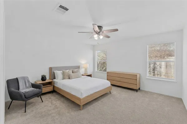 an empty room with windows and fan