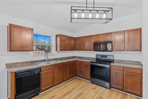a kitchen with stainless steel appliances granite countertop a stove sink and microwave