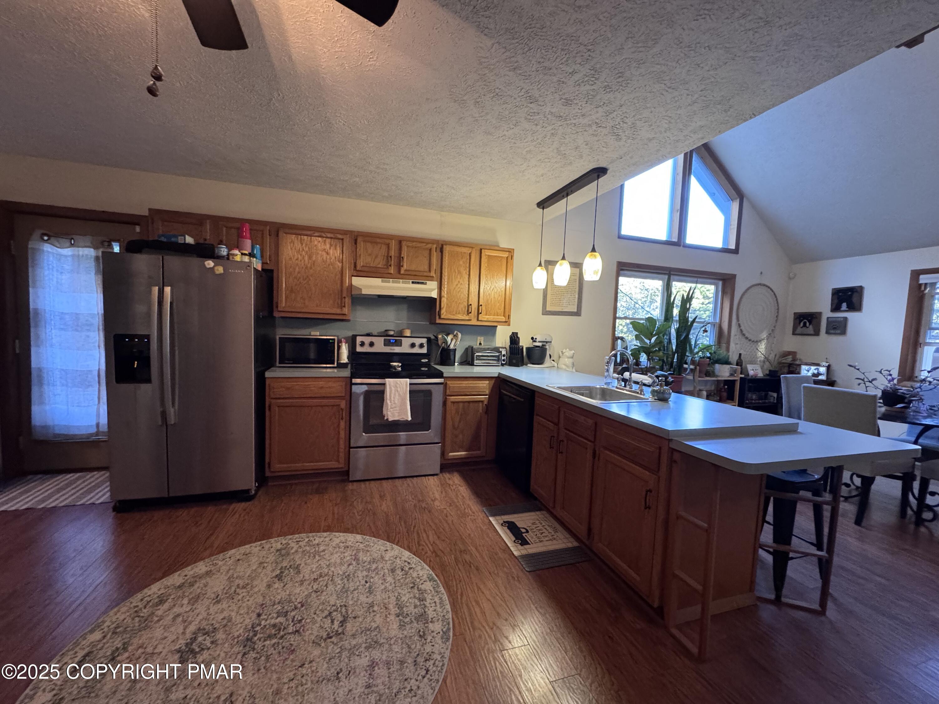 67 Seneca Road Albrightsville, PA 18210 - Photo 13 of 52 a kitchen with stainless steel appliances granite countertop a refrigerator a stove a sink a dining table and chairs with wooden floor