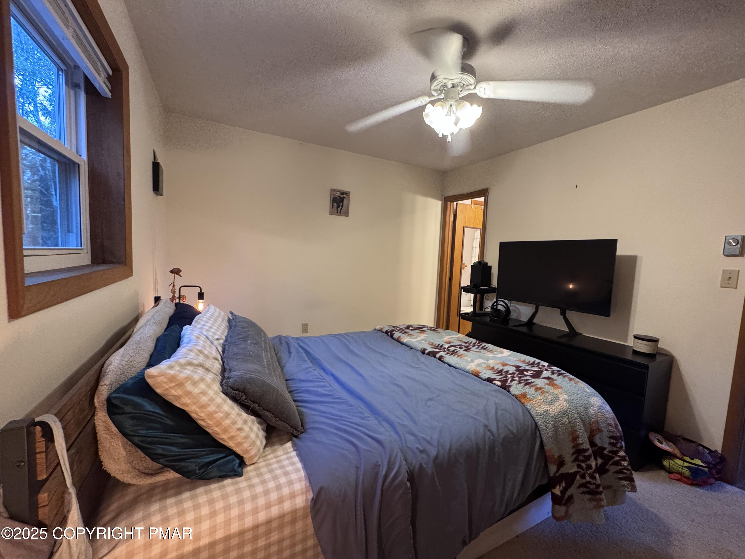 67 Seneca Road Albrightsville, PA 18210 - Photo 17 of 52 a bed sitting in a bedroom next to a window and a chandelier