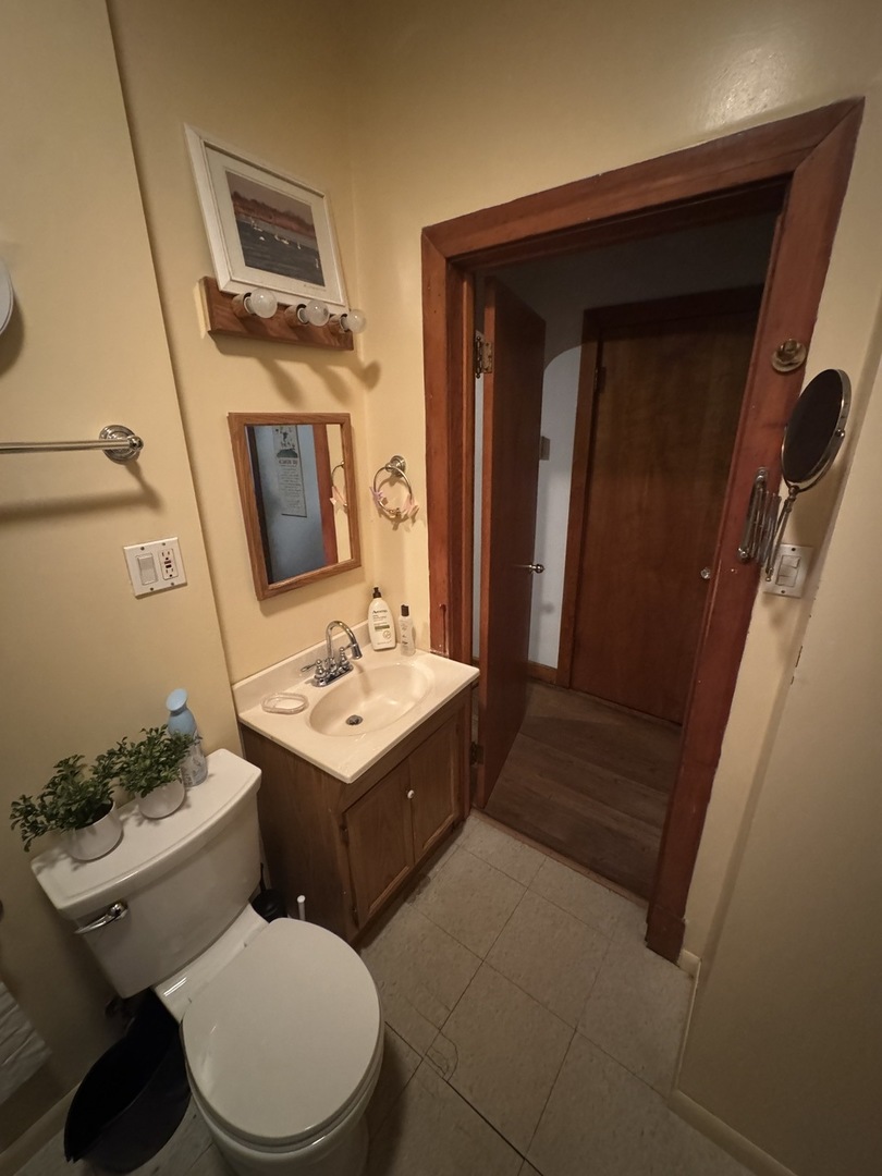 3945 West 55th Place Chicago, IL 60629 - Photo 11 of 21 a bathroom with a toilet a sink and a mirror