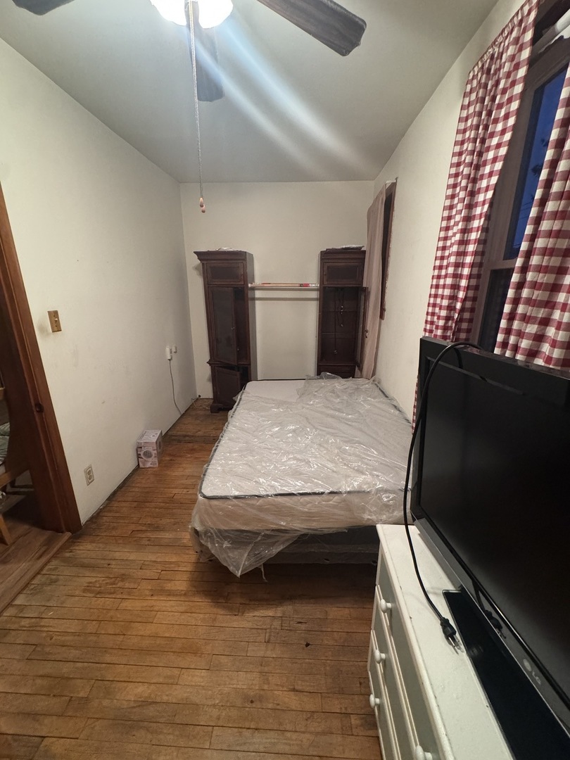 3945 West 55th Place Chicago, IL 60629 - Photo 17 of 21 a bedroom with a bed and a flat tv screen on a dresser