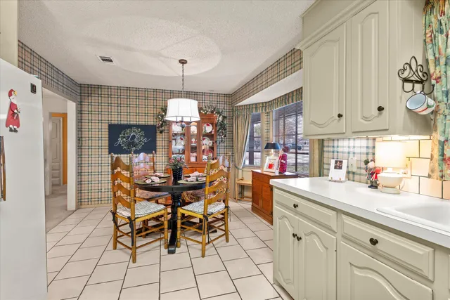 a kitchen with stainless steel appliances a dining table chairs and sink