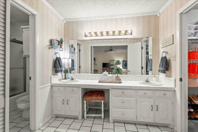 a spacious bathroom with a granite countertop sink a toilet and a mirror