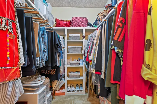 a view of walk in closet with clothes