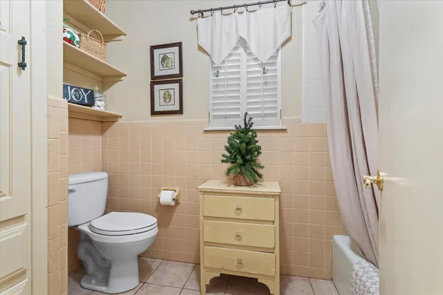 a bathroom with a toilet a sink and a shower curtain