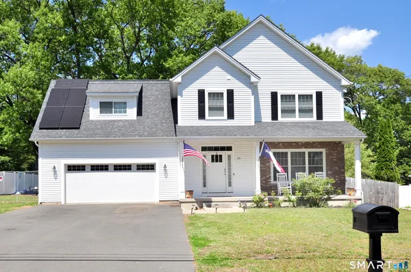 a front view of a house with a yard garage and outdoor seating