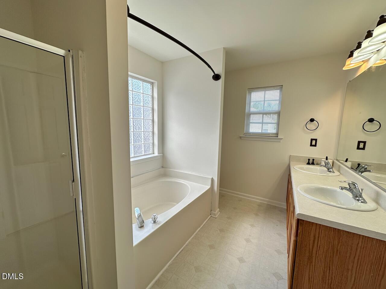 5413 Kissimmee Lane Raleigh, NC 27616 - Photo 16 of 26 a bathroom with a tub a sink and a mirror