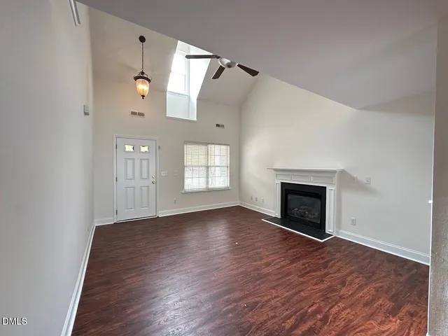 a view of empty room with wooden floor and fireplace