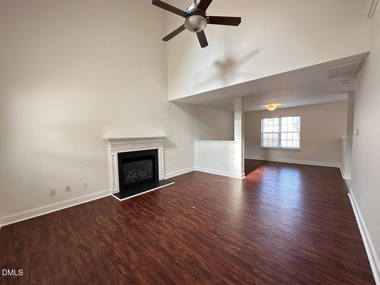 5413 Kissimmee Lane Raleigh, NC 27616 - Photo 4 of 26 an empty room with wooden floor fireplace and windows