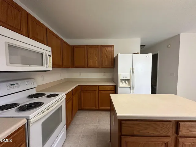 a kitchen with a stove a refrigerator and a microwave
