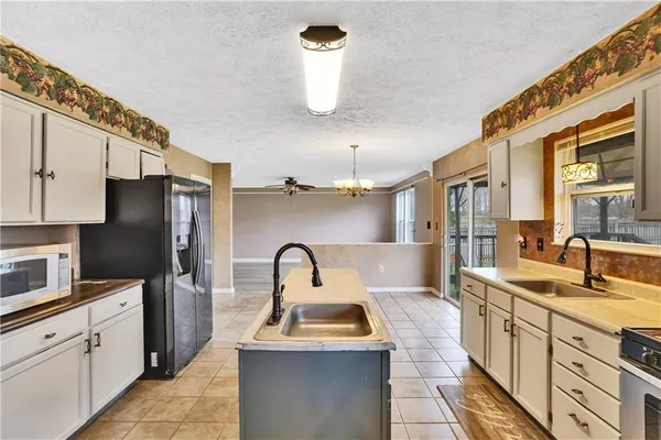 a kitchen with kitchen island stainless steel appliances a sink stove and refrigerator