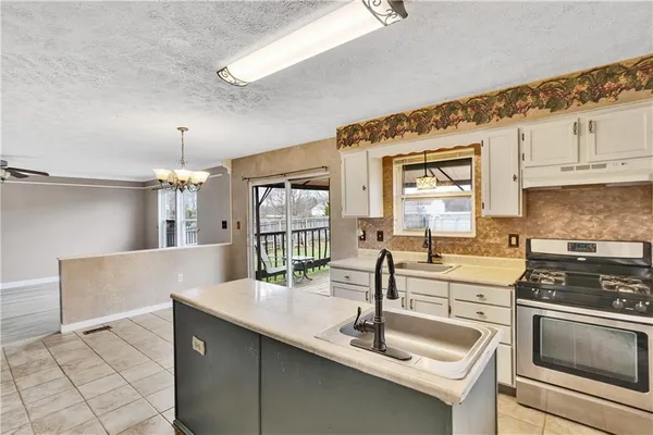 a kitchen with granite countertop a sink and white cabinets