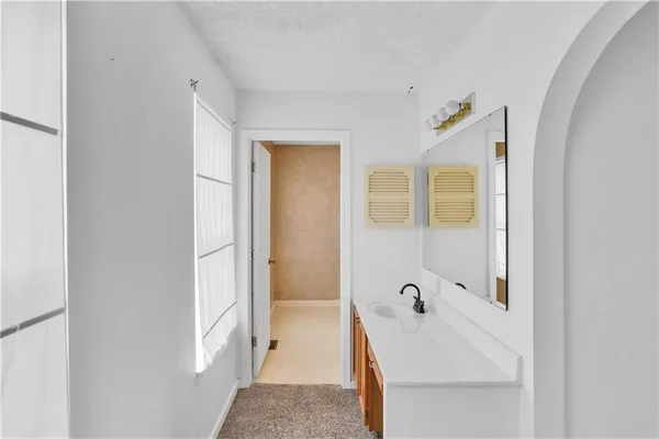 a bathroom with a tub sink and mirror