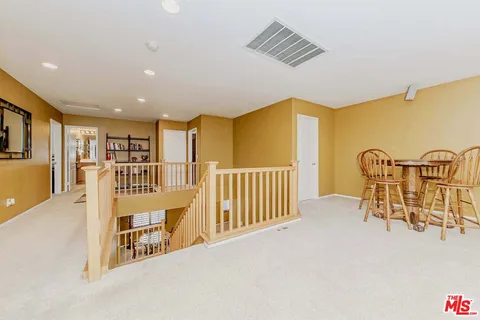 a view of a hallway with wooden floor and furniture