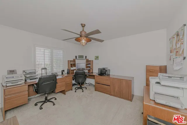 a view of a workspace with furniture and a window