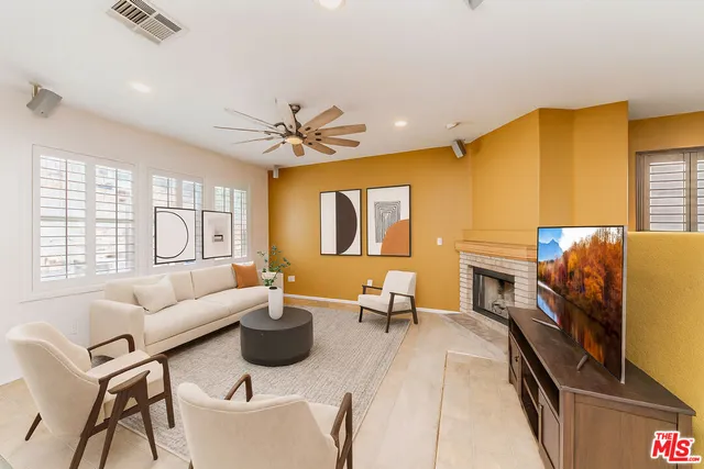 a living room with furniture a fireplace and a flat screen tv
