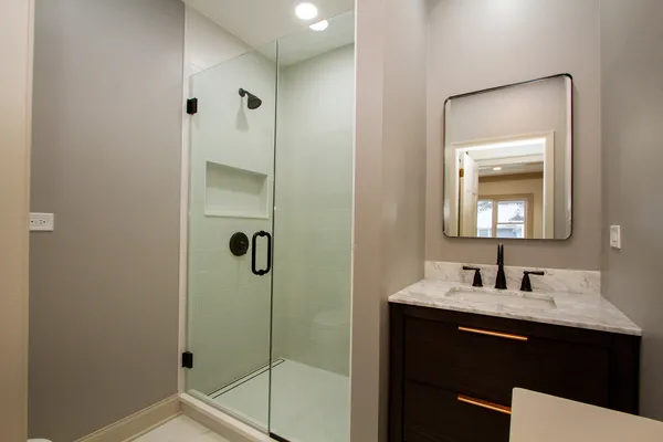 a bathroom with a shower sink and mirror