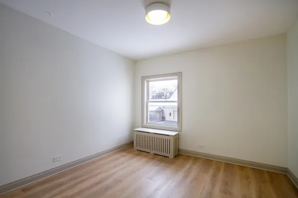 a view of a room with wooden floor and a window