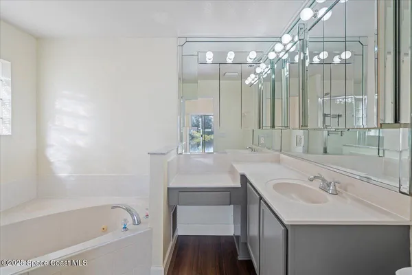 a bathroom with a tub sink and mirror