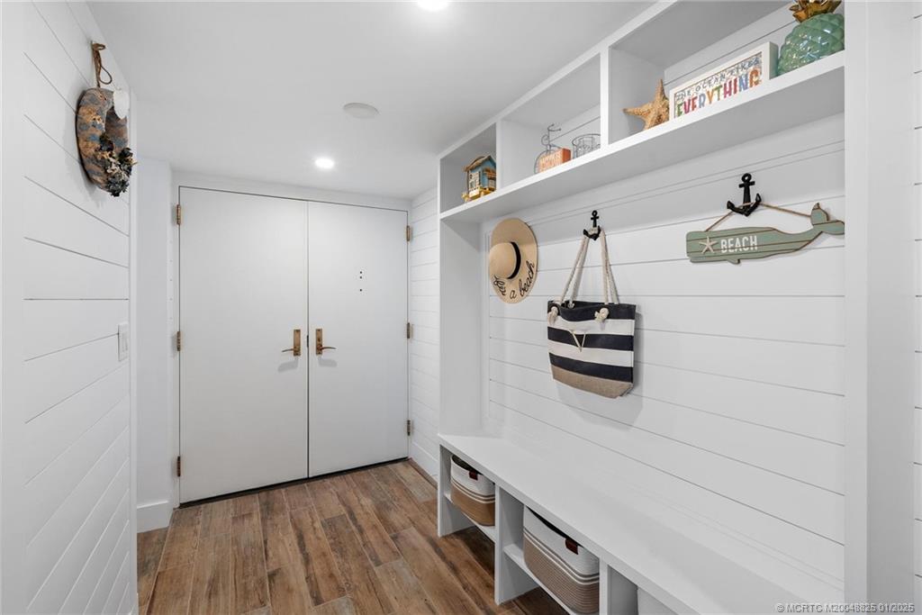 8750 South Ocean Drive, Unit 1435 Jensen Beach, FL 34957 - Photo 15 of 38 a hallway with a white cabinet and wooden floor