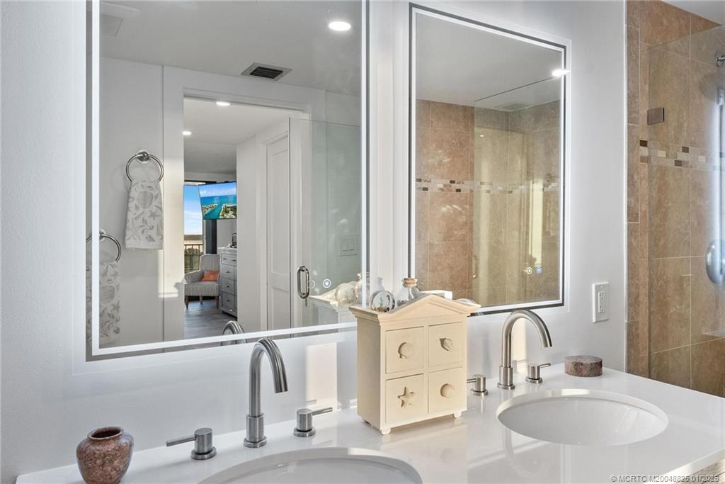 8750 South Ocean Drive, Unit 1435 Jensen Beach, FL 34957 - Photo 21 of 38 a bathroom with double vanity sinks and a mirror