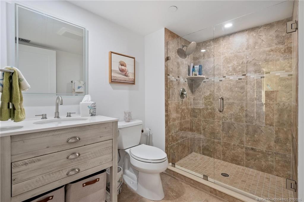 8750 South Ocean Drive, Unit 1435 Jensen Beach, FL 34957 - Photo 29 of 38 a bathroom with a shower sink vanity mirror and toilet