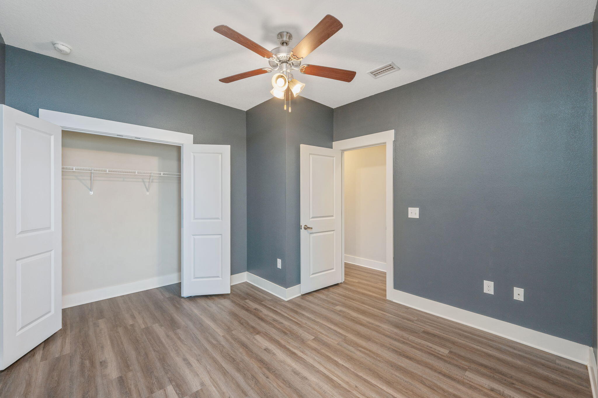 275 North Sand Palm Road, Unit 167VISTA Freeport, FL 32439 - Photo 22 of 40 an empty room with wooden floor and a ceiling fan