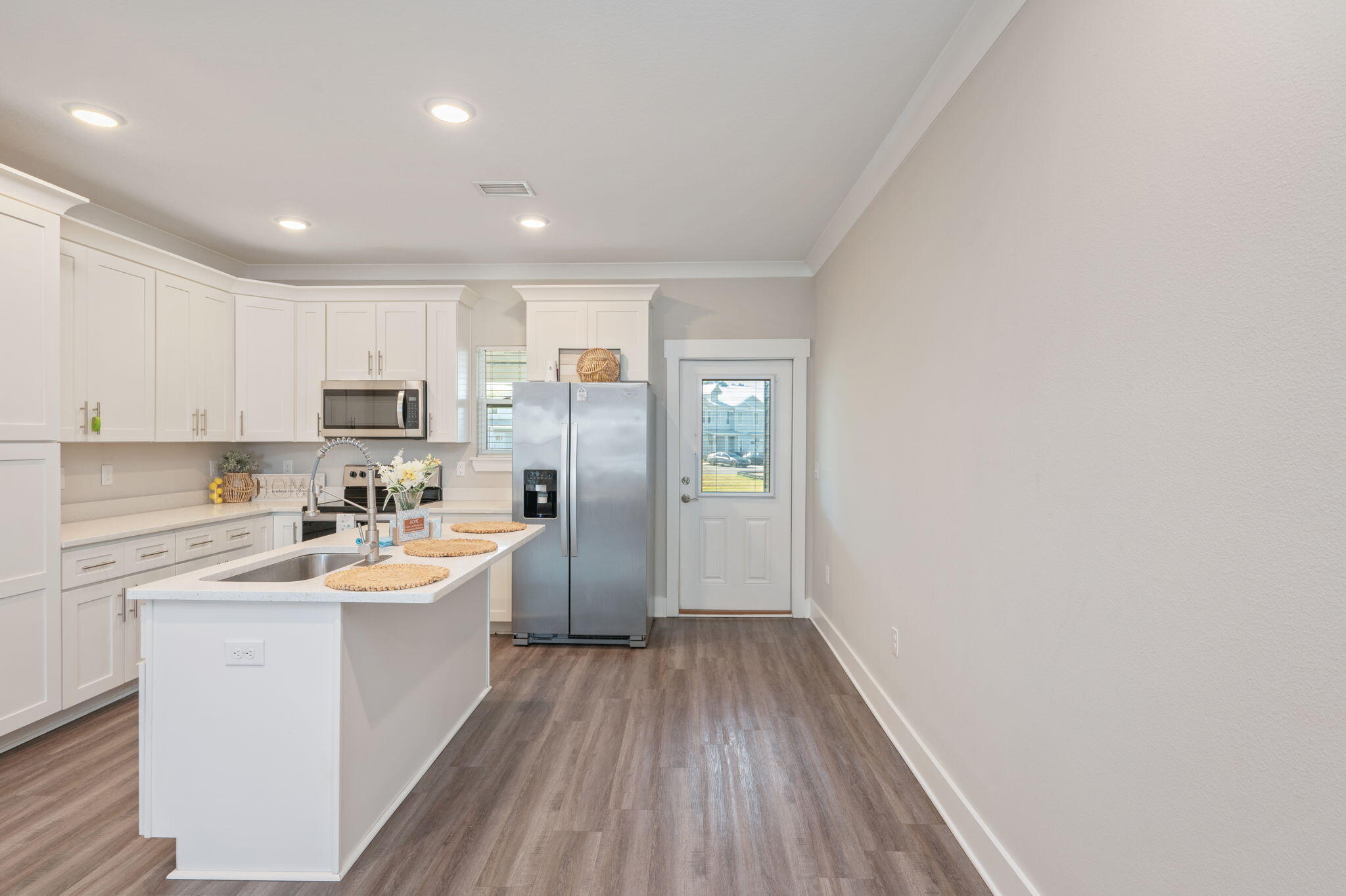 275 North Sand Palm Road, Unit 167VISTA Freeport, FL 32439 - Photo 9 of 40 a kitchen with wooden floors and white cabinets